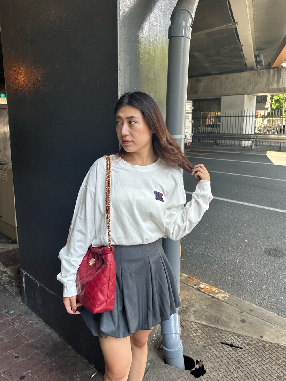 ホワイト系のTシャツ/カットソー、グレー系のスカート、ブラック系のブーツを着用したレディースの秋コーディネートの4枚目の写真