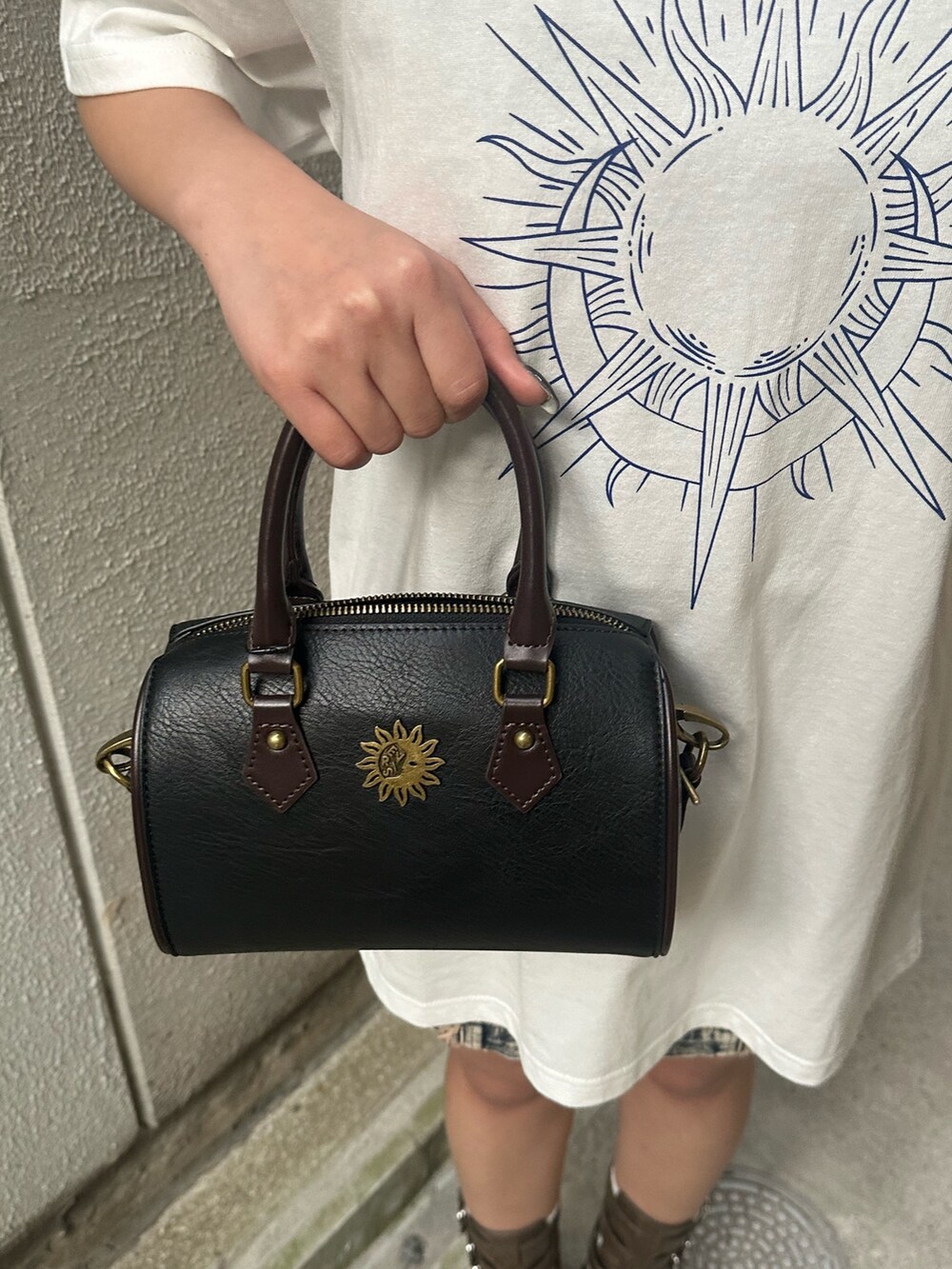 ホワイト系のTシャツ/カットソー、ブラック系のショルダーバッグ、ブラウン系のブーツを着用したレディースの夏コーディネートの6枚目の写真