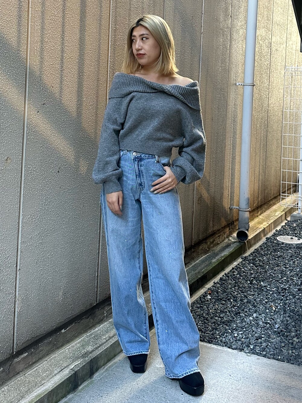 ブルー系のデニムパンツ、グレー系のニット/セーター、その他のブーツを着用したレディースの秋コーディネートの2枚目の写真