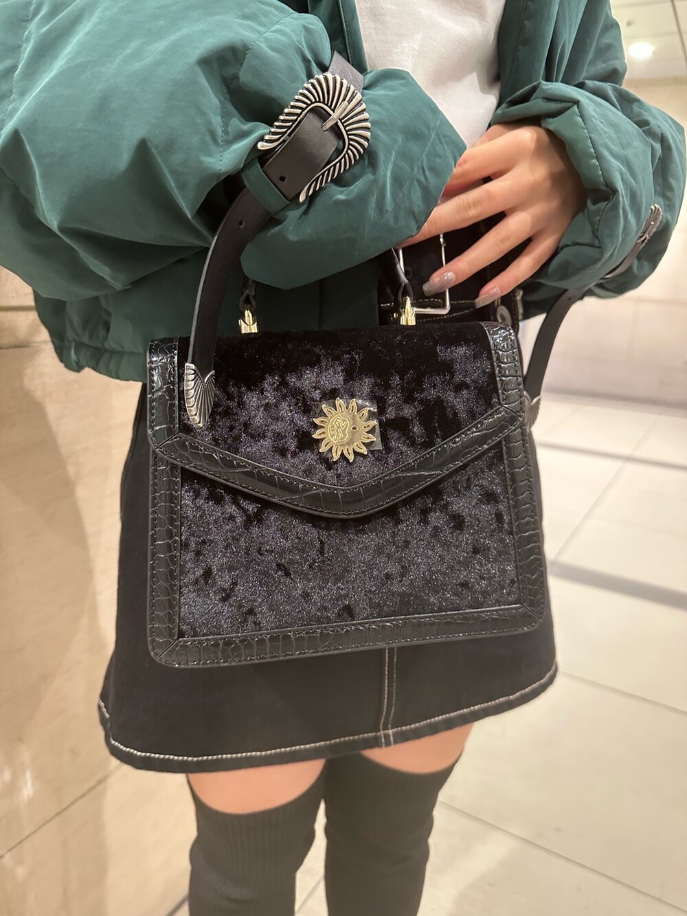 ブルー系のデニムスカート、ホワイト系のTシャツ/カットソー、グリーン系のダウンジャケット/コートを着用したレディースの秋コーディネートの7枚目の写真