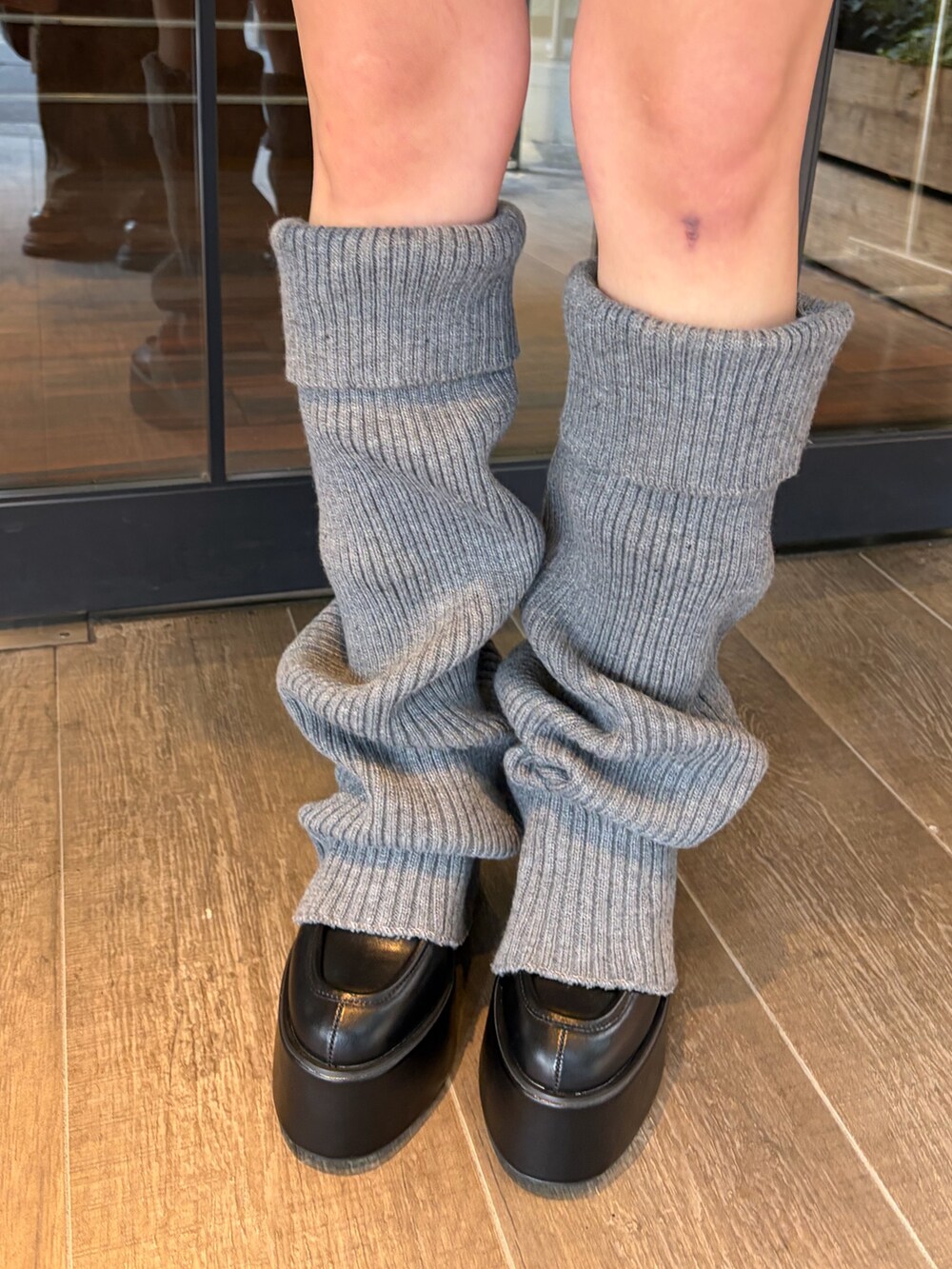 ブラック系のブルゾン、ホワイト系のニット/セーター、ホワイト系のスカートを着用したレディースの冬コーディネートの5枚目の写真