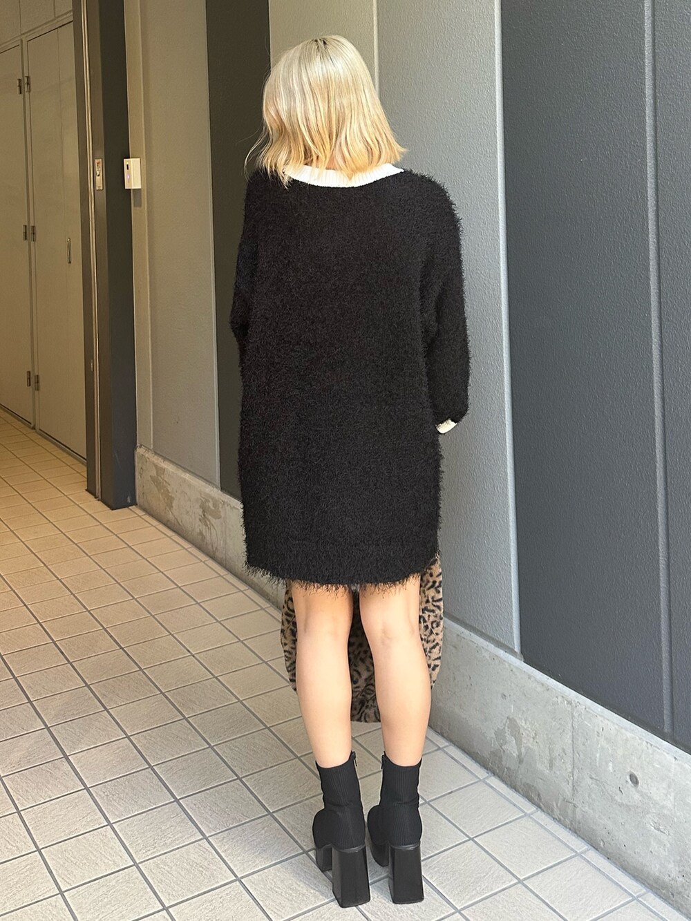 その他のブーツ、ブラック系のニット/セーター、その他のショルダーバッグを着用したレディースの秋コーディネートの3枚目の写真