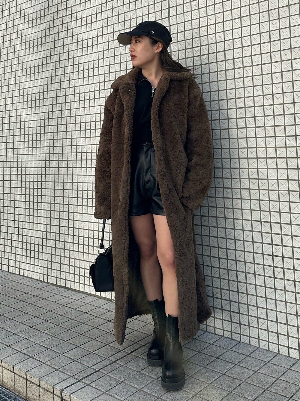 ブラック系のブーツ、ブラック系のハンドバッグ、ブラック系のその他パンツを着用したレディースの冬コーディネートの2枚目の写真