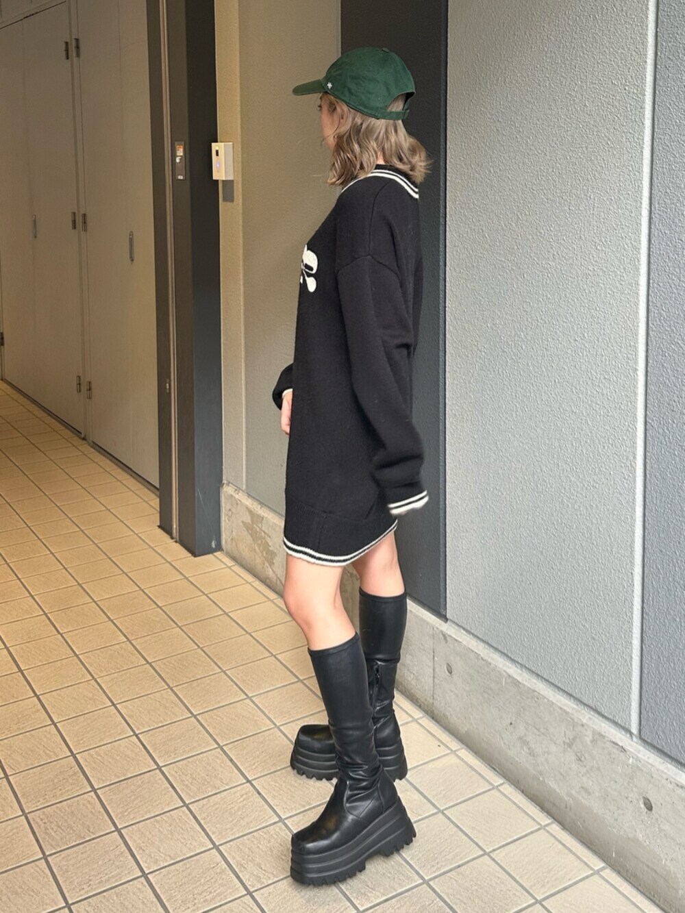 ブラック系のブーツ、ブルー系のデニムスカート、ブラック系のニット/セーターを着用したレディースの冬コーディネートの2枚目の写真