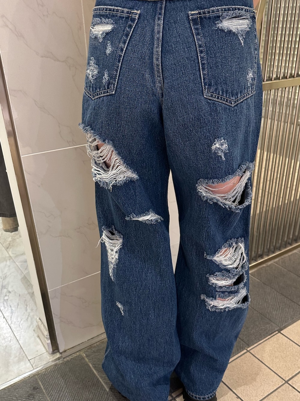 ホワイト系のシャツ/ブラウス、ブルー系のデニムパンツ、ブラック系のサンダルを着用したレディースの春コーディネートの6枚目の写真