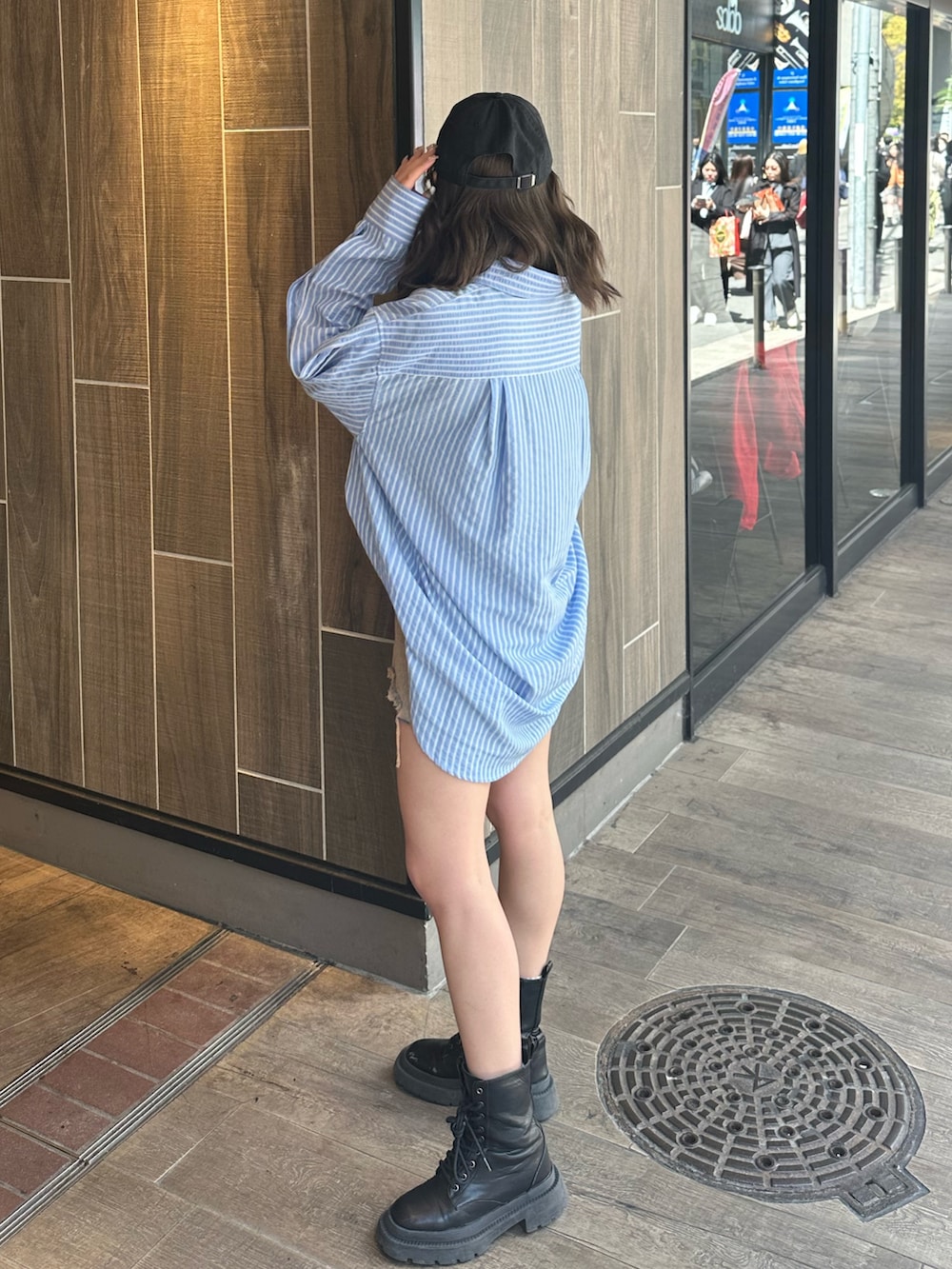 ブルー系のシャツ/ブラウス、ブラック系のブーツ、ベージュ系のデニムパンツを着用したレディースの春コーディネートの2枚目の写真