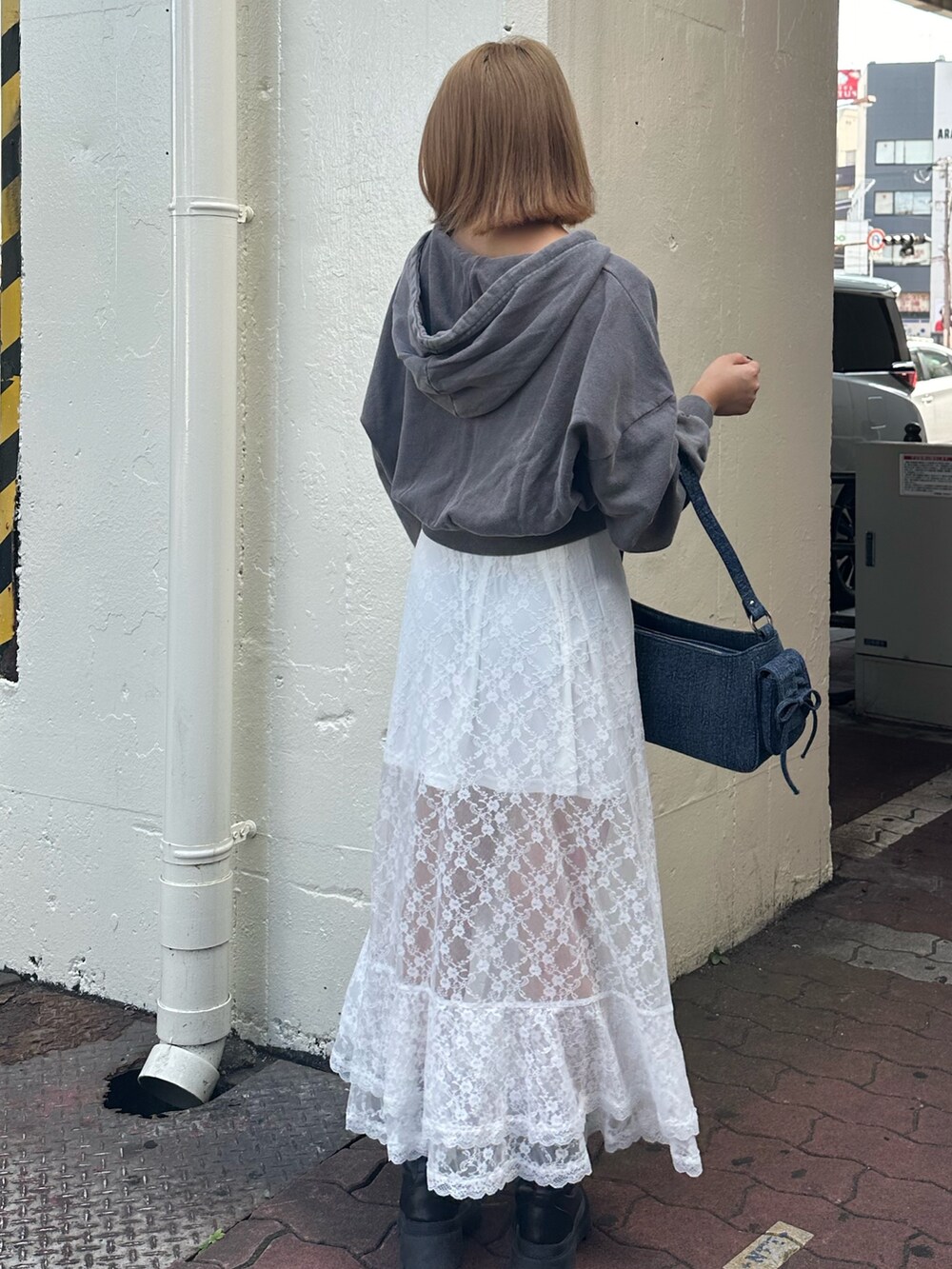 ホワイト系のスカート、グレー系のスウェット、ブラック系のブーツを着用したレディースの秋コーディネートの4枚目の写真