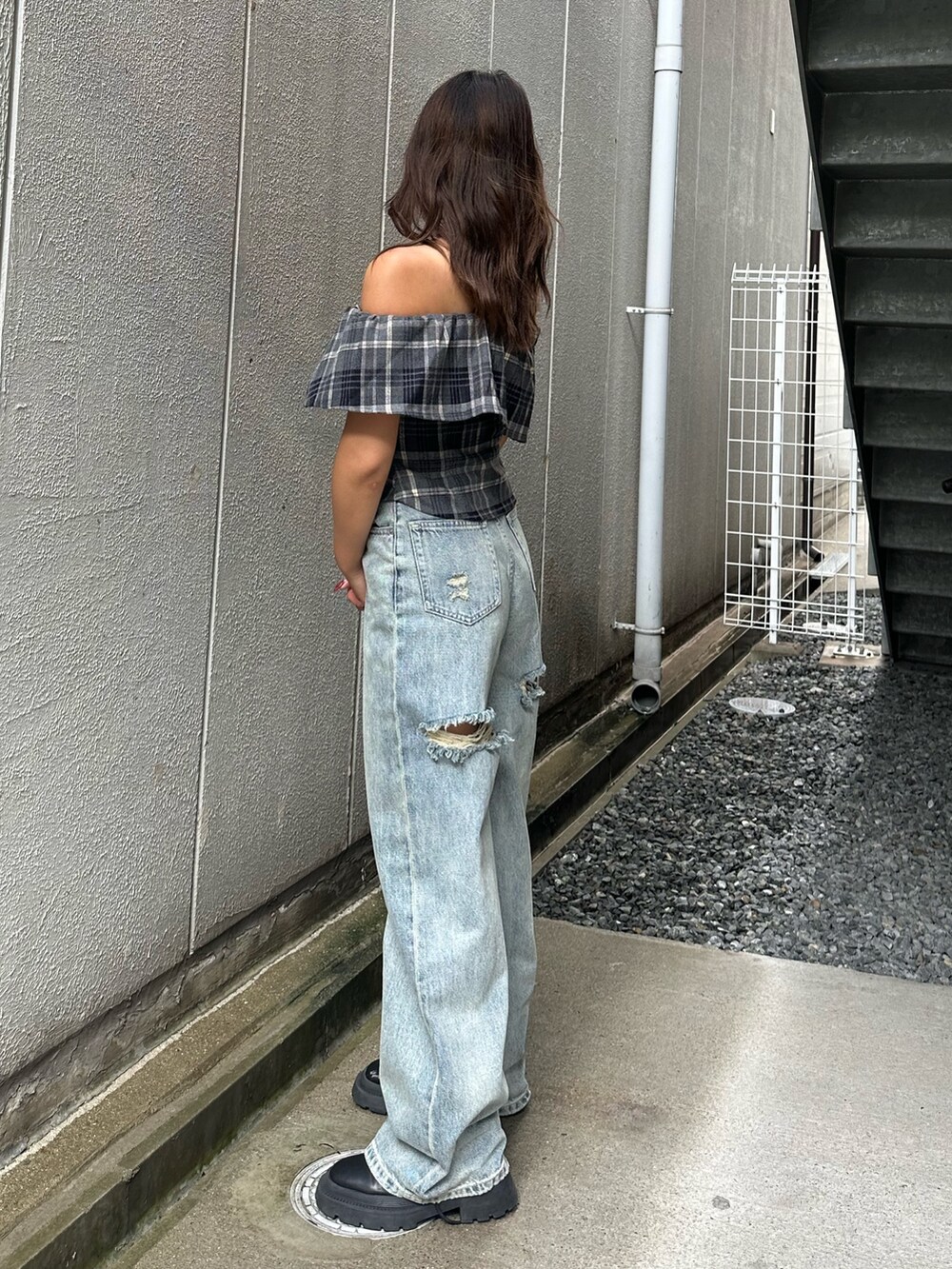 ブラック系のシャツ/ブラウス、ブルー系のデニムパンツ、ブラック系のブーツを着用したレディースの夏コーディネートの2枚目の写真