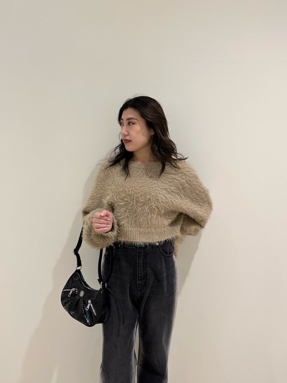 ベージュ系のニット/セーター、ブラック系のショルダーバッグ、ブラック系のブーツを着用したレディースの冬コーディネートの4枚目の写真