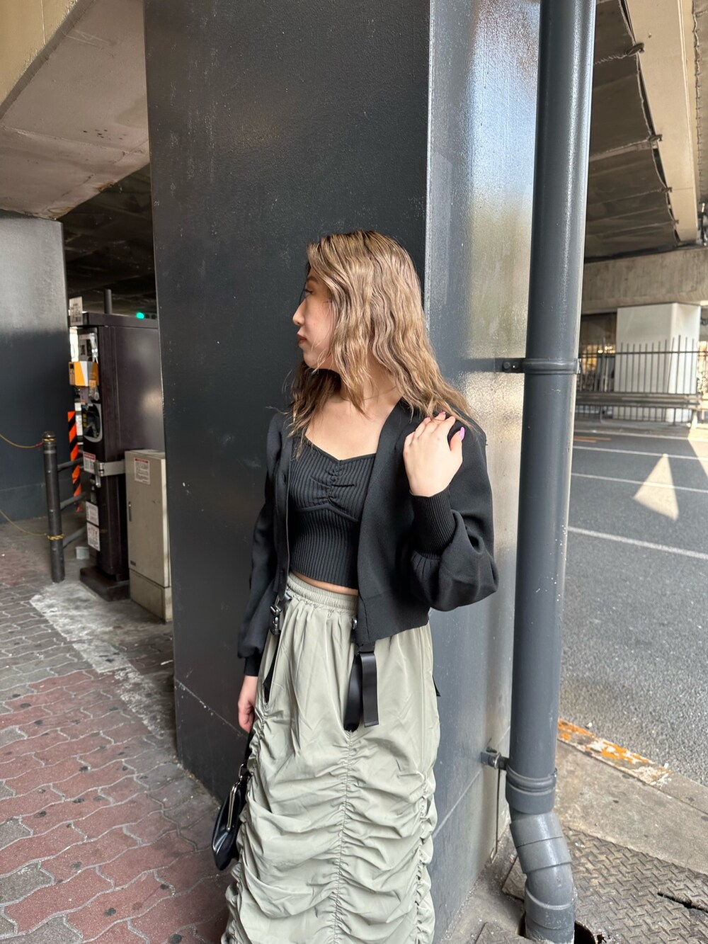 ベージュ系のスカート、ブラック系のカーディガン/ボレロ、ブラック系のショルダーバッグを着用したレディースの春コーディネートの4枚目の写真