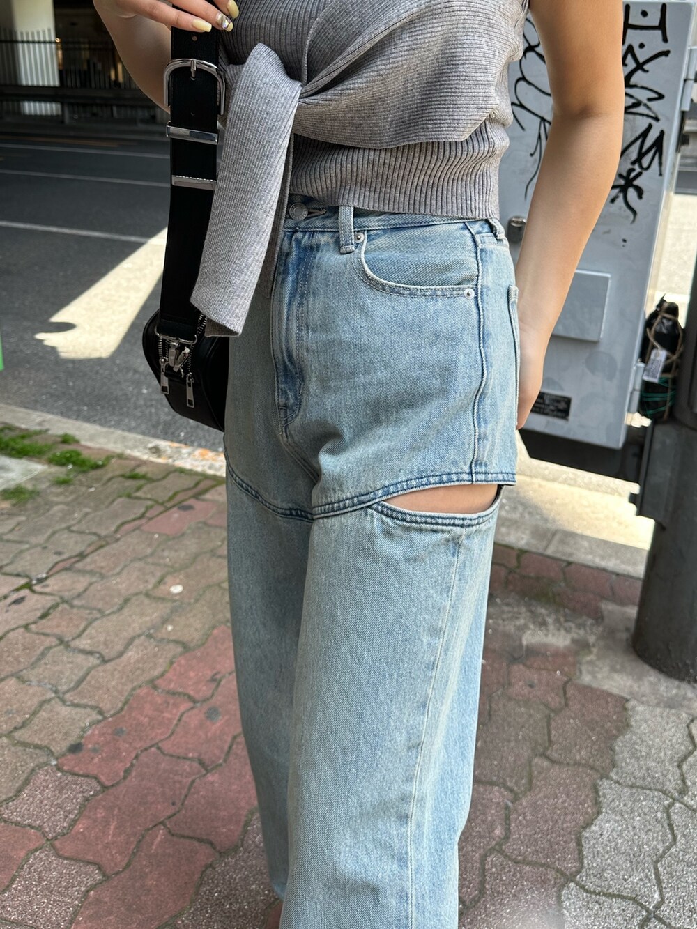 ブラック系のサンダル、ブラック系のショルダーバッグ、グレー系のチューブトップを着用したレディースの春コーディネートの6枚目の写真