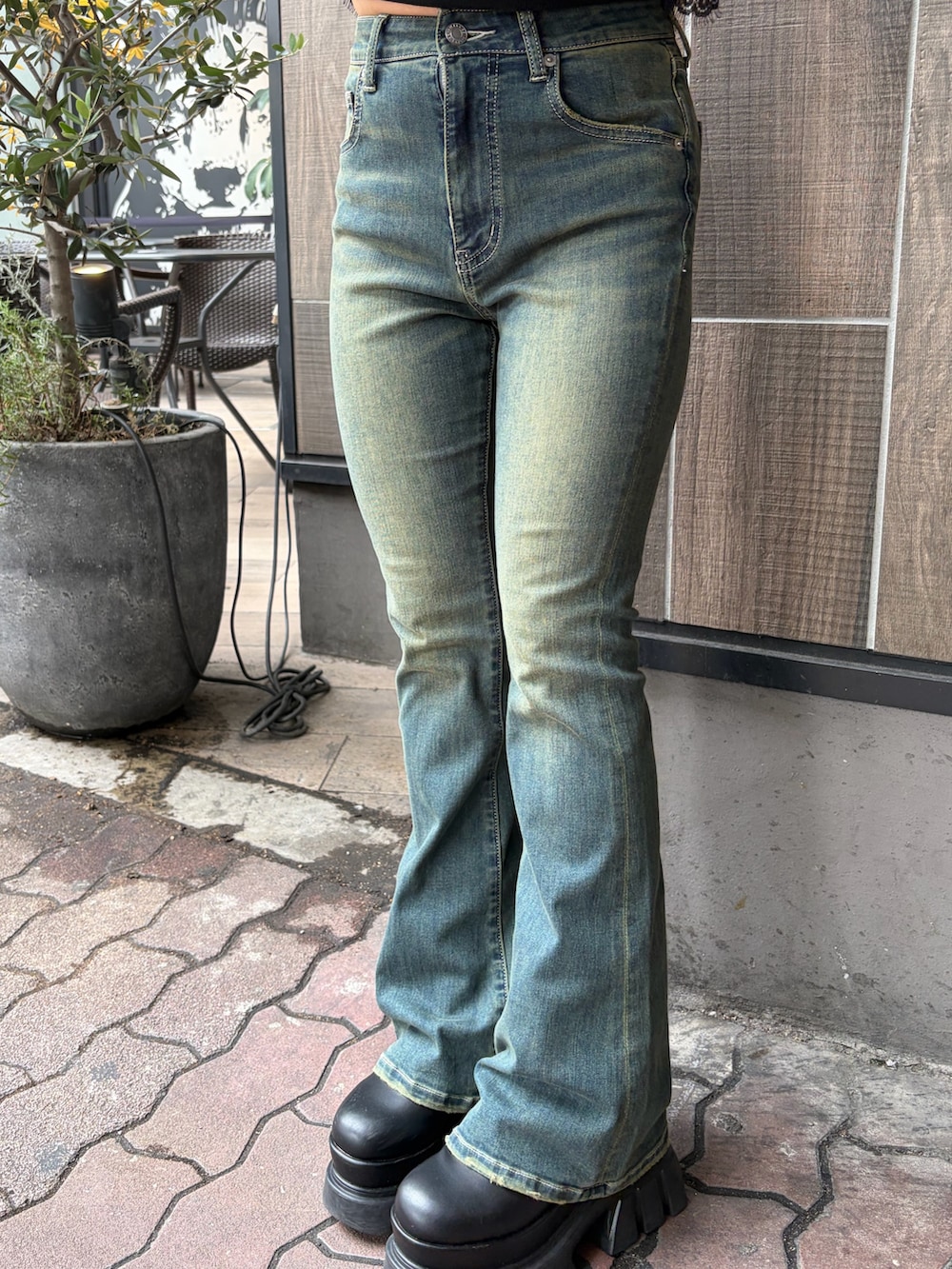 ブルー系のデニムパンツ、ブラック系のブーツ、ブラック系のミリタリージャケットを着用したレディースの秋コーディネートの6枚目の写真