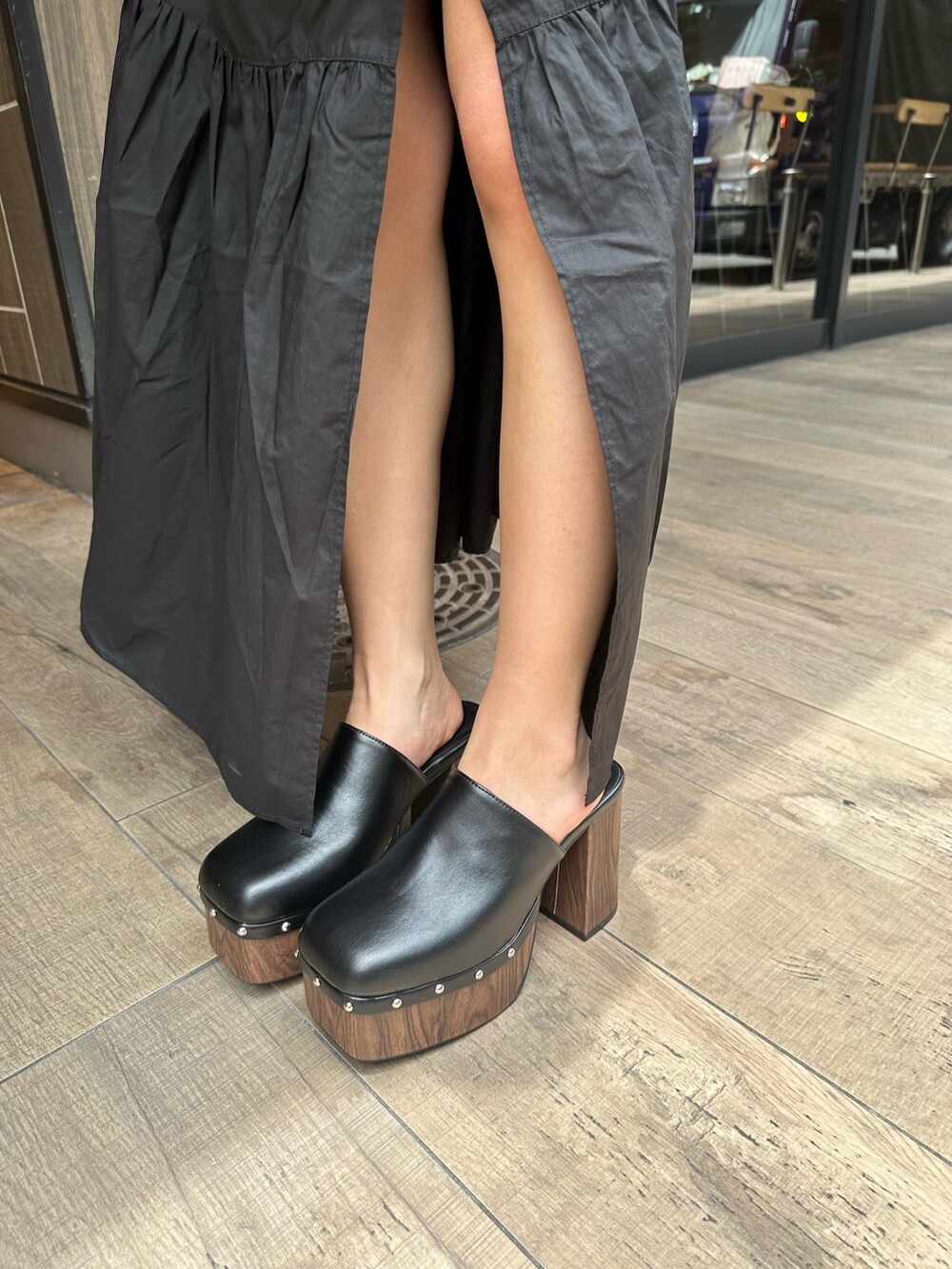 ブラック系のワンピース、ブラック系のサンダル、ベージュ系のトートバッグを着用したレディースの夏コーディネートの7枚目の写真