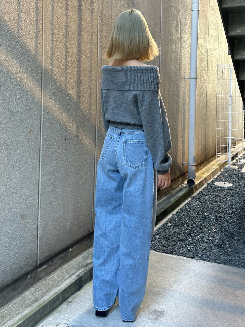 ブルー系のデニムパンツ、グレー系のニット/セーター、その他のブーツを着用したレディースの秋コーディネートの4枚目の写真