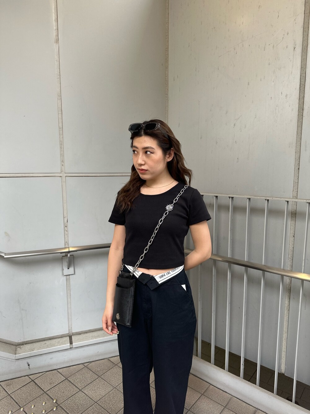 ブラック系のその他パンツ、ブラック系のショルダーバッグ、ブラック系のTシャツ/カットソーを着用したレディースの春コーディネートの4枚目の写真