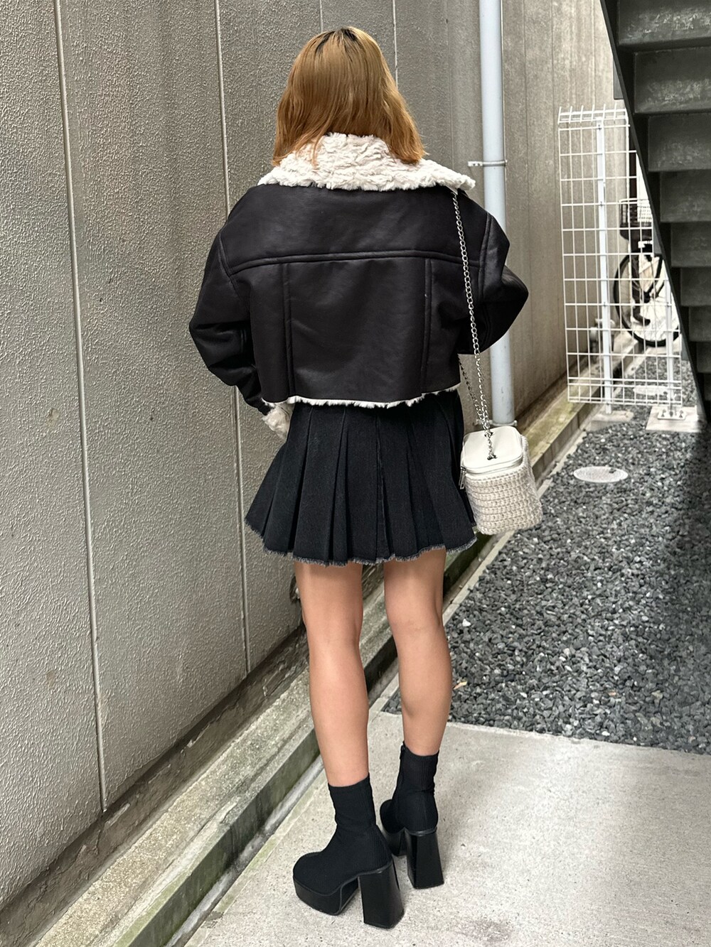 ブラック系のデニムスカート、その他のブーツ、ホワイト系のショルダーバッグを着用したレディースの秋コーディネートの3枚目の写真