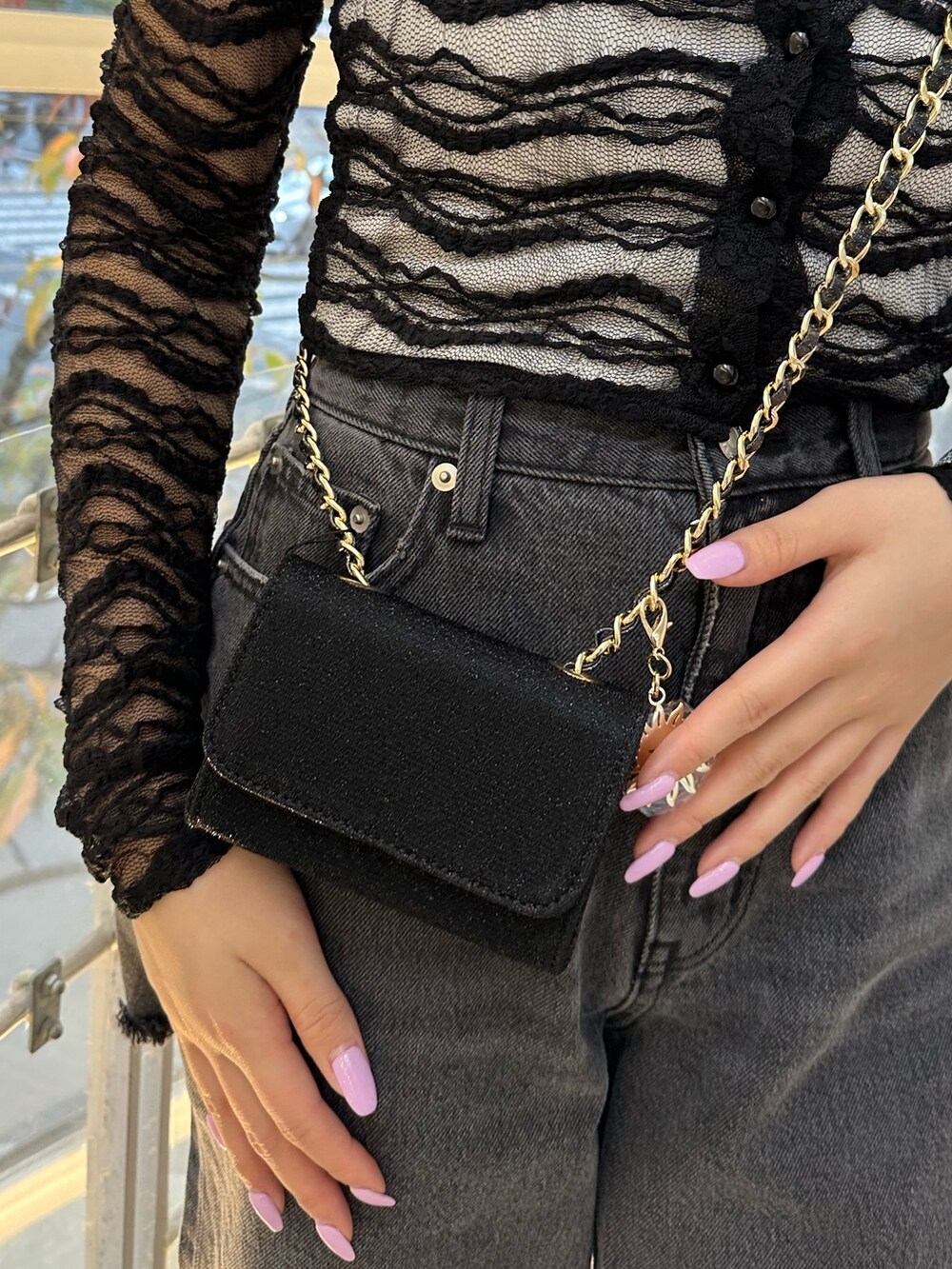 ブラック系のショルダーバッグ、ブラック系のデニムパンツ、ブラック系のTシャツ/カットソーを着用したレディースの冬コーディネートの6枚目の写真