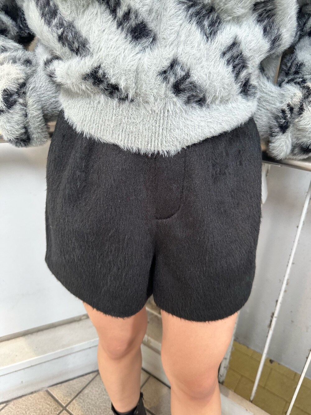 ブラック系のその他パンツ、ブラック系のブーツ、グレー系のニット/セーターを着用したレディースの冬コーディネートの6枚目の写真