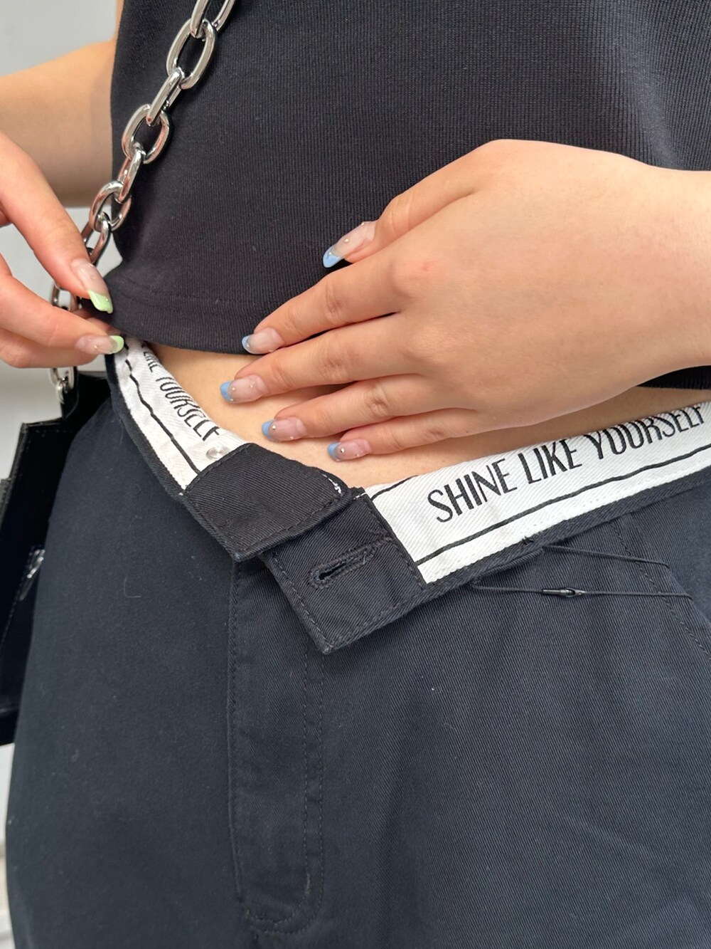 ブラック系のその他パンツ、ブラック系のショルダーバッグ、ブラック系のTシャツ/カットソーを着用したレディースの春コーディネートの6枚目の写真