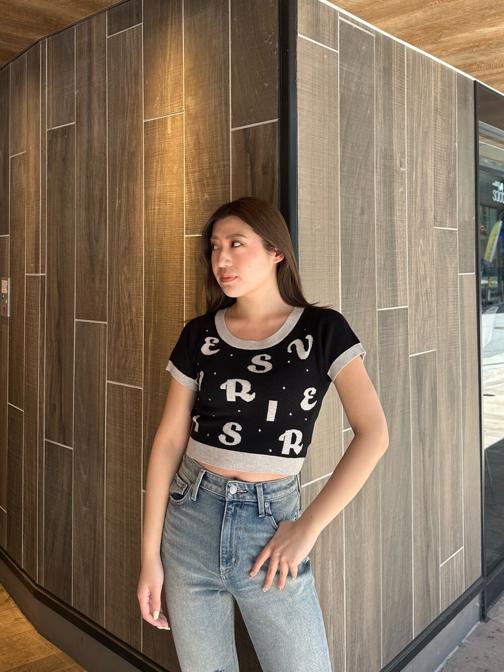 ブラック系のニット/セーター、ブルー系のデニムパンツ、その他のサンダルを着用したレディースの春コーディネートの4枚目の写真