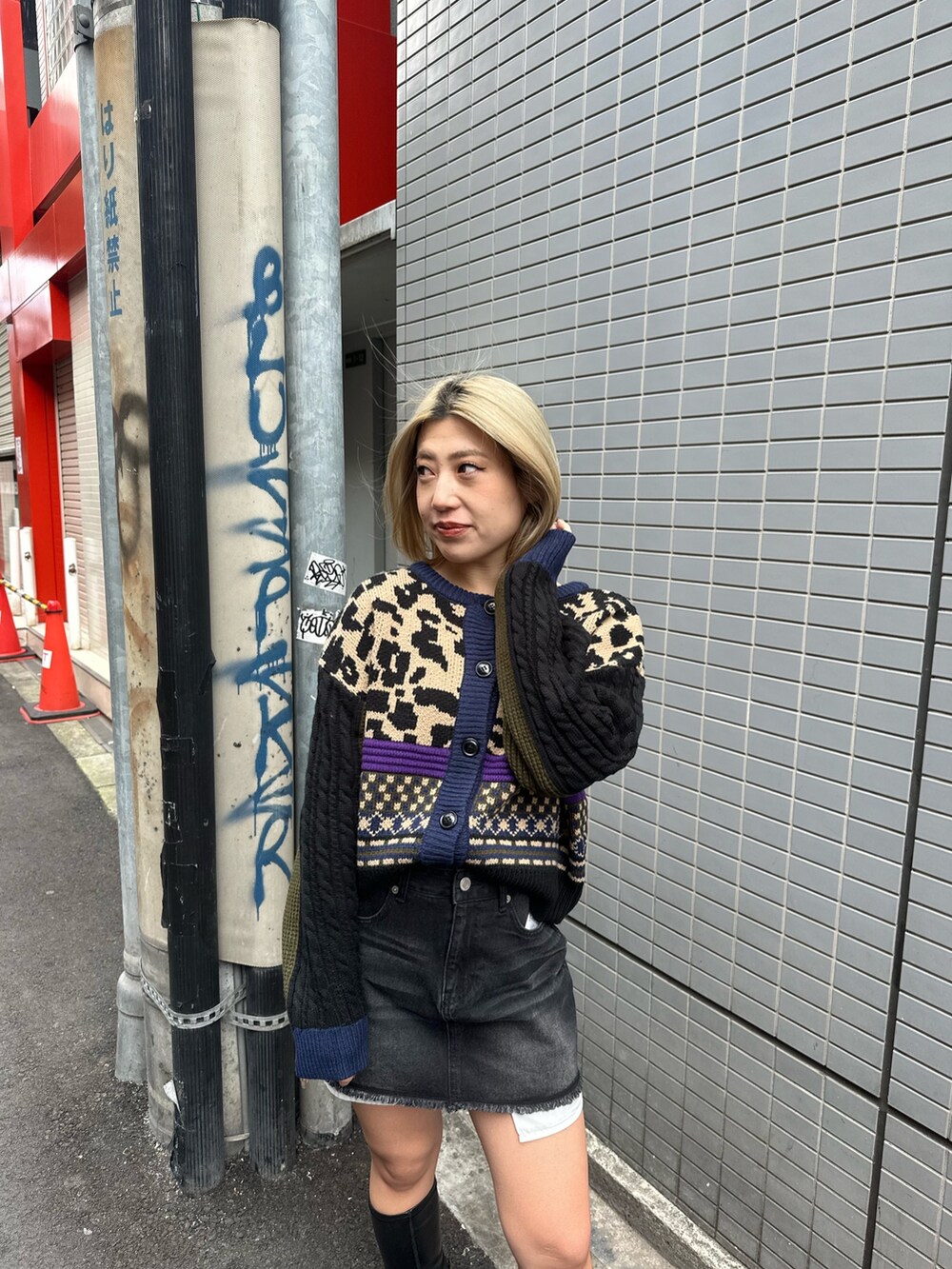 ブラック系のブーツ、ベージュ系のニット/セーター、ブラック系のデニムスカートを着用したレディースの冬コーディネートの4枚目の写真