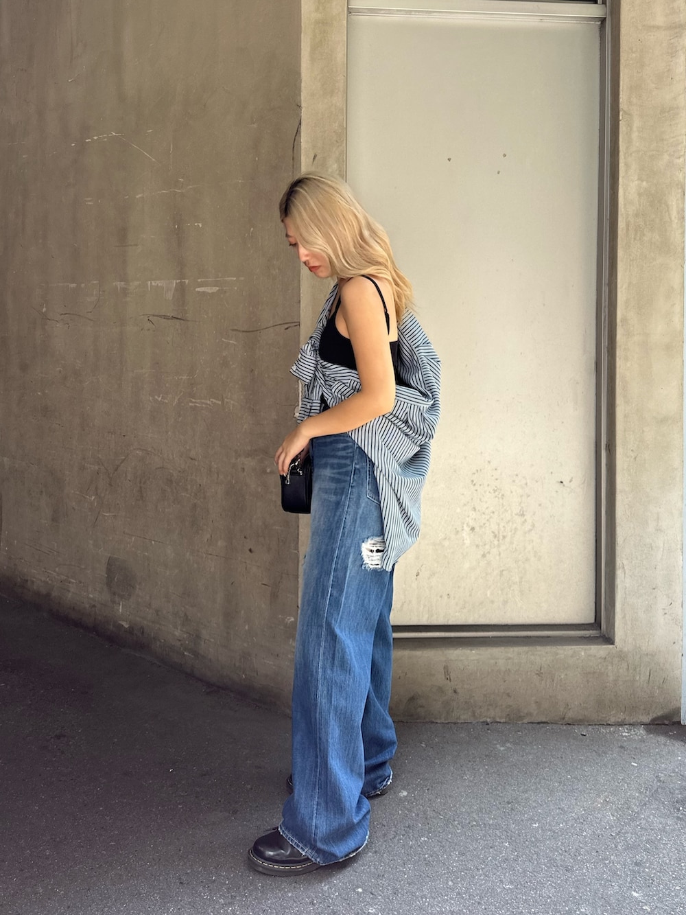 ブルー系のデニムパンツ、ブラック系のショルダーバッグ、グリーン系のシャツ/ブラウスを着用したレディースの夏コーディネートの2枚目の写真