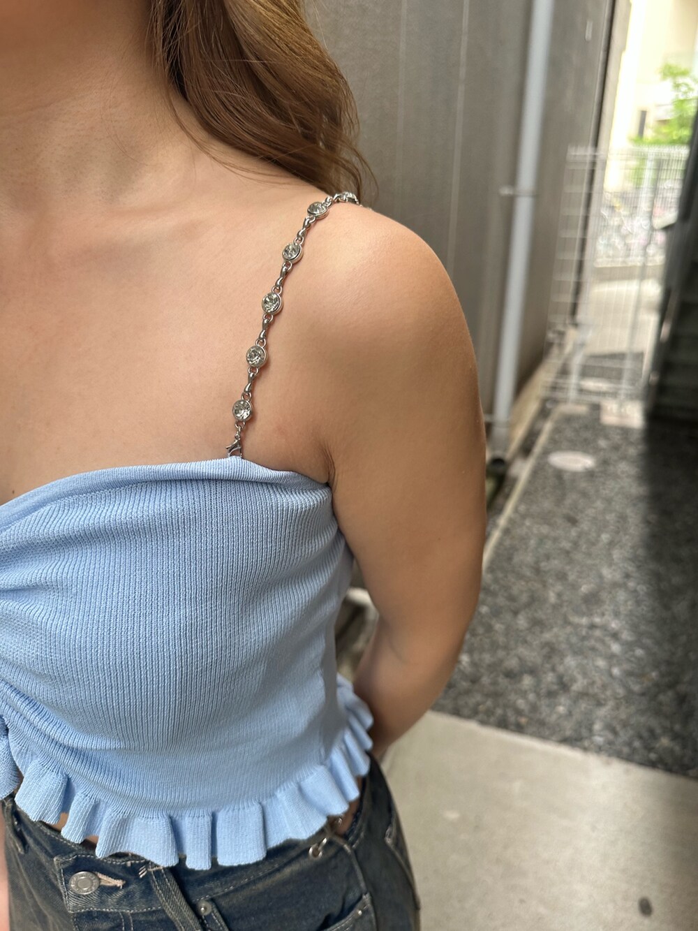 ブルー系のデニムパンツ、ブラック系のサンダル、ブルー系のキャミソールを着用したレディースの夏コーディネートの5枚目の写真