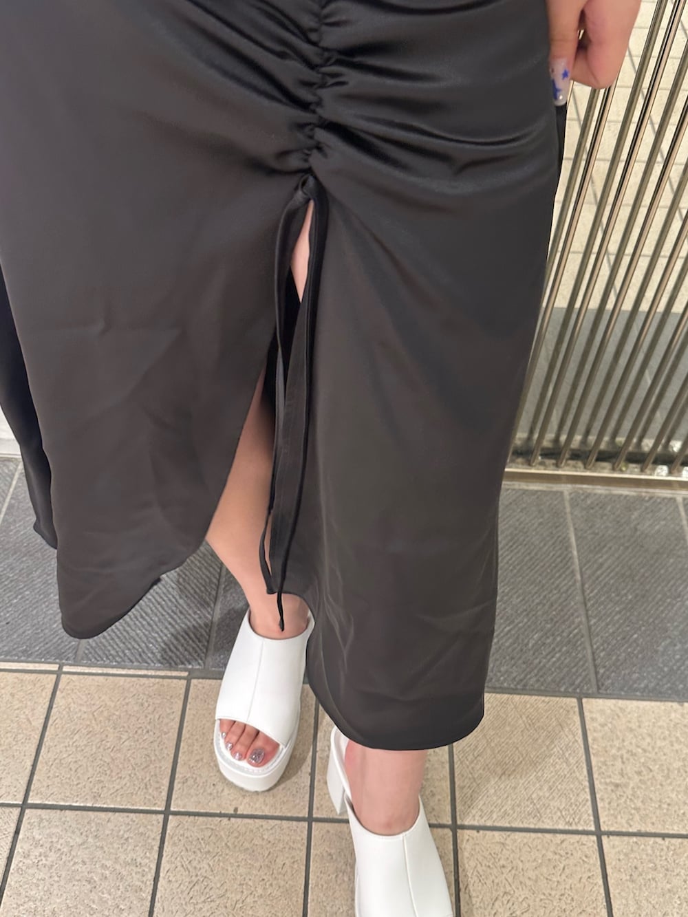 ブラック系のワンピース、ブラック系のトートバッグ、ホワイト系のサンダルを着用したレディースの夏コーディネートの9枚目の写真