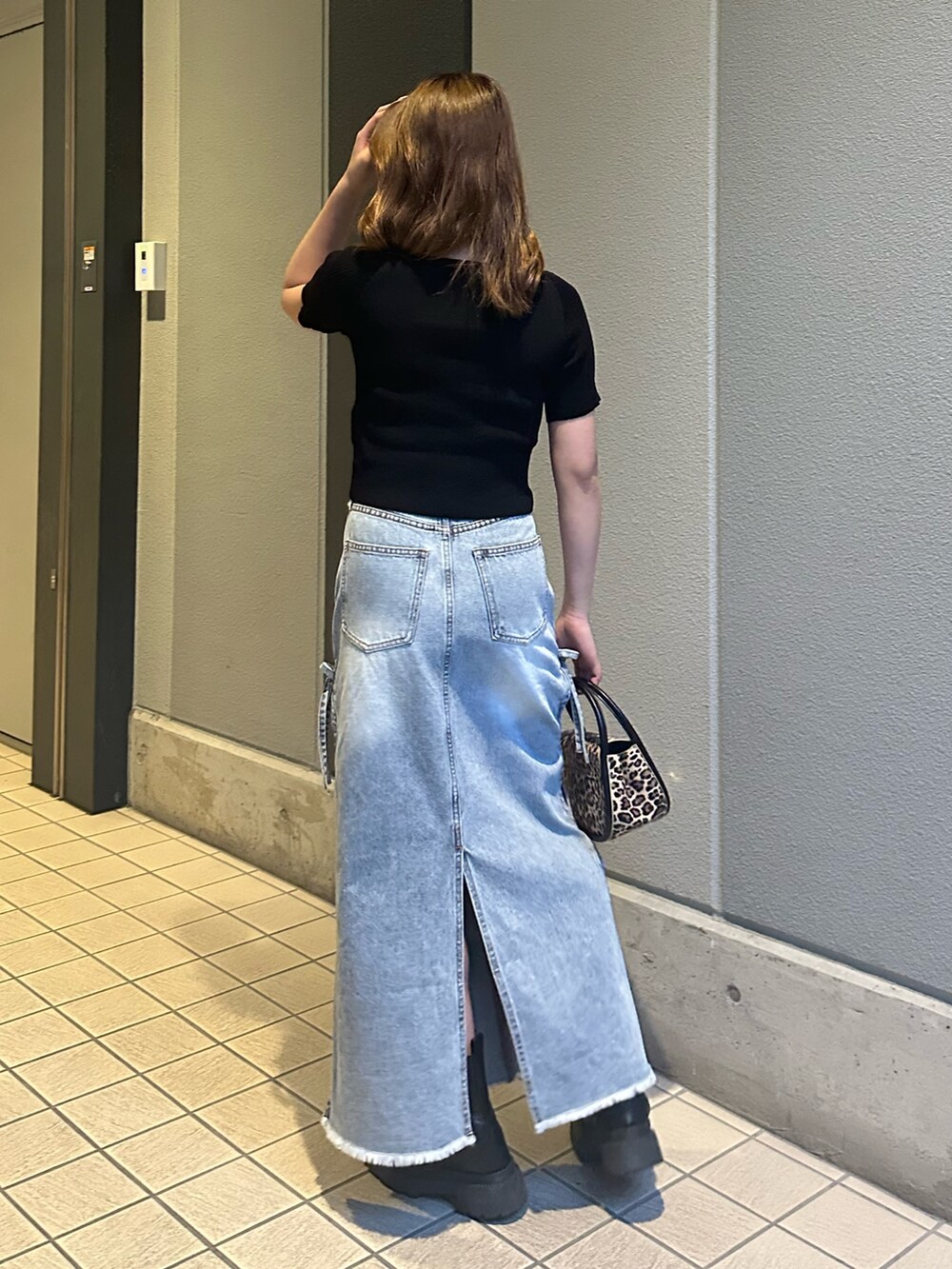 ブルー系のデニムスカート、その他のハンドバッグ、ブラック系のブーツを着用したレディースの春コーディネートの3枚目の写真