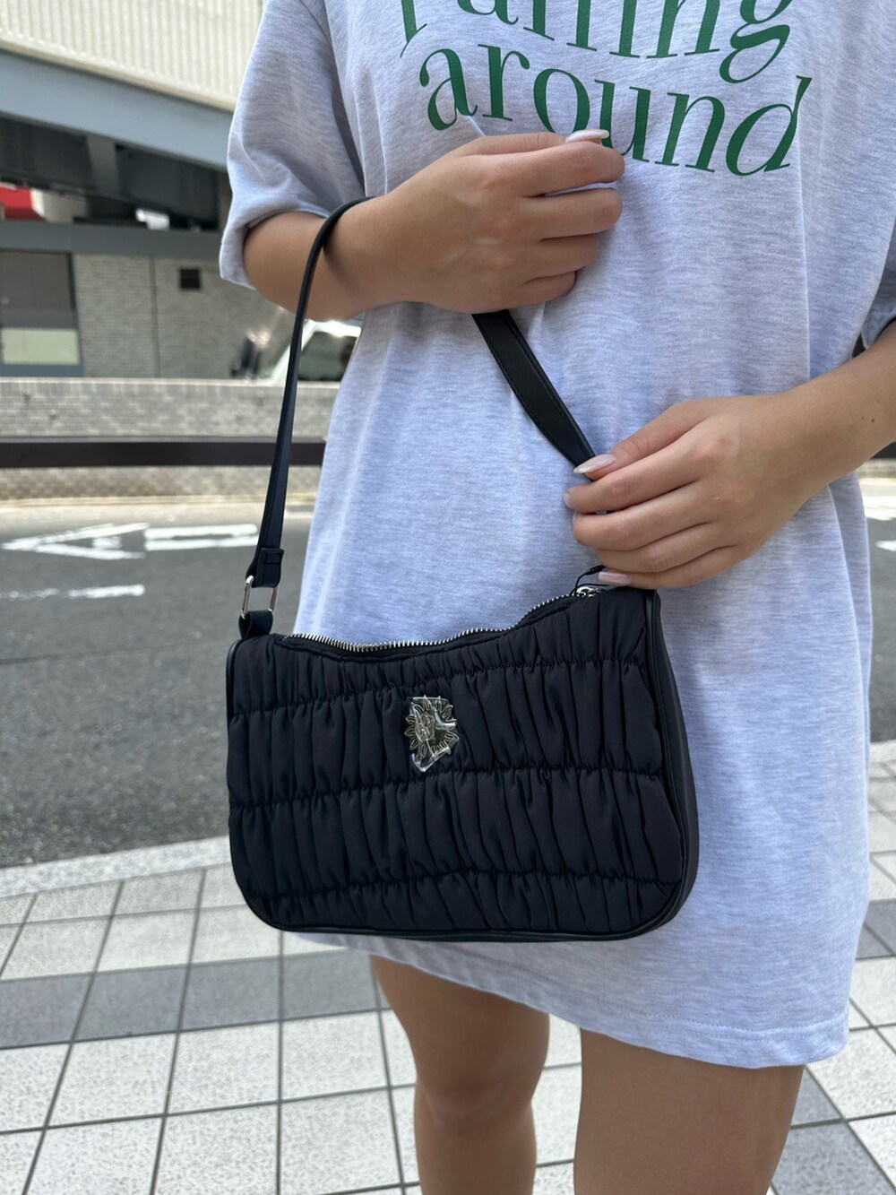 グレー系のTシャツ/カットソー、ブラック系のハンドバッグ、ブラック系のブーツを着用したレディースの夏コーディネートの6枚目の写真