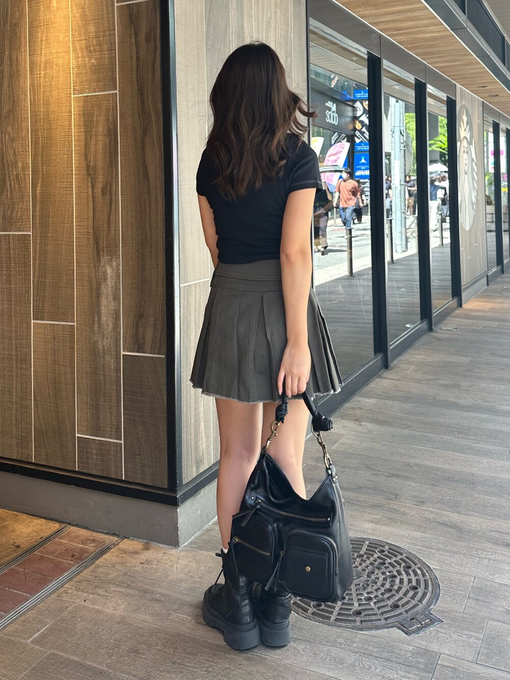 ブラック系のTシャツ/カットソー、グレー系のスカート、ブラック系のハンドバッグを着用したレディースの夏コーディネートの4枚目の写真