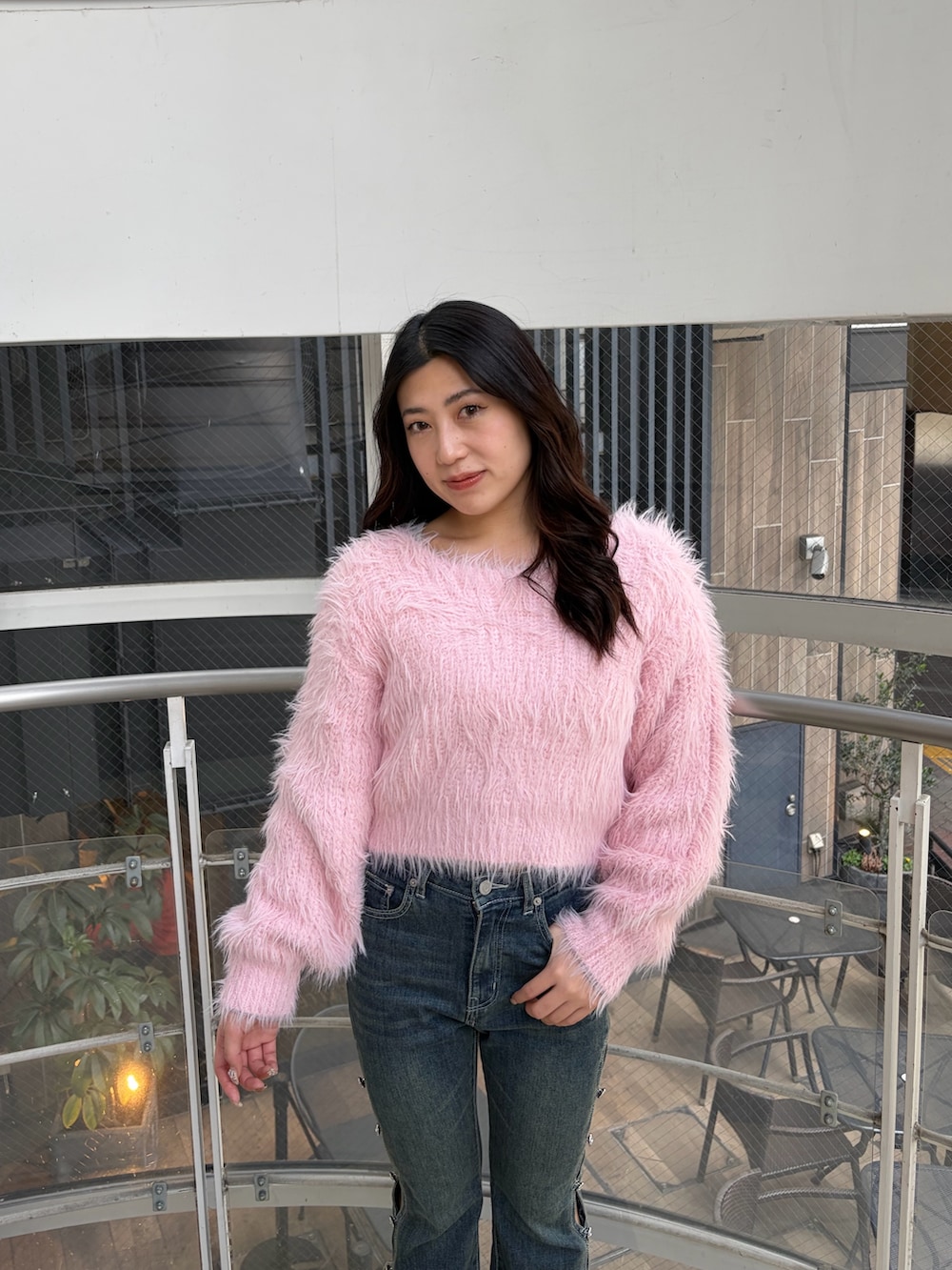 ブルー系のデニムパンツ、ピンク系のニット/セーター、ブラック系のブーツを着用したレディースの冬コーディネートの6枚目の写真