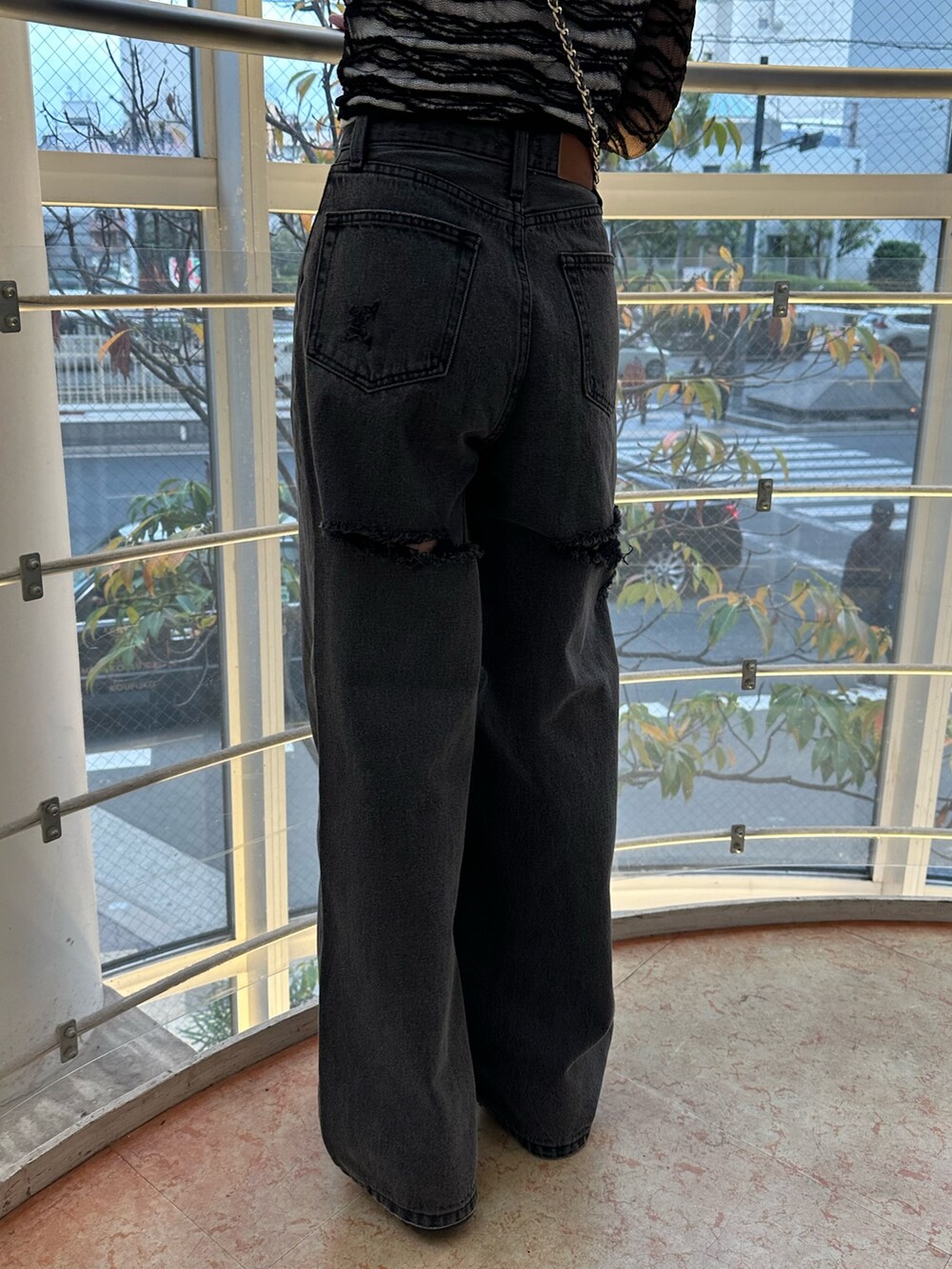 ブラック系のショルダーバッグ、ブラック系のデニムパンツ、ブラック系のTシャツ/カットソーを着用したレディースの冬コーディネートの7枚目の写真