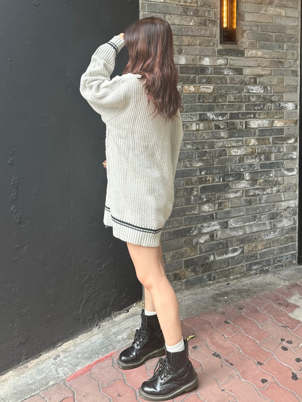 グレー系のニット/セーター、ホワイト系のショルダーバッグを着用したレディースの夏コーディネートの2枚目の写真