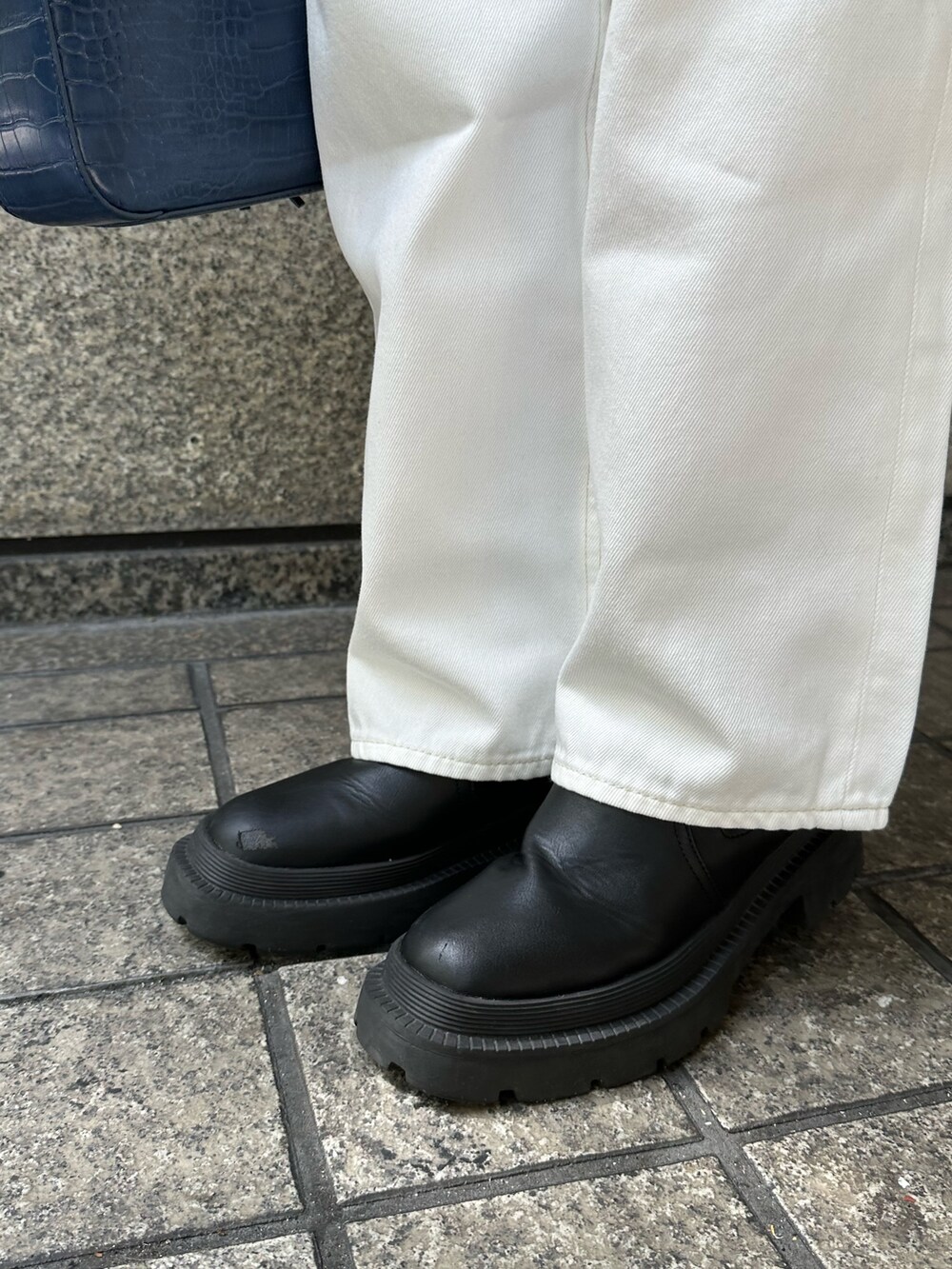 ホワイト系のニット/セーター、ホワイト系のデニムパンツ、ブルー系のショルダーバッグを着用したレディースの春コーディネートの9枚目の写真