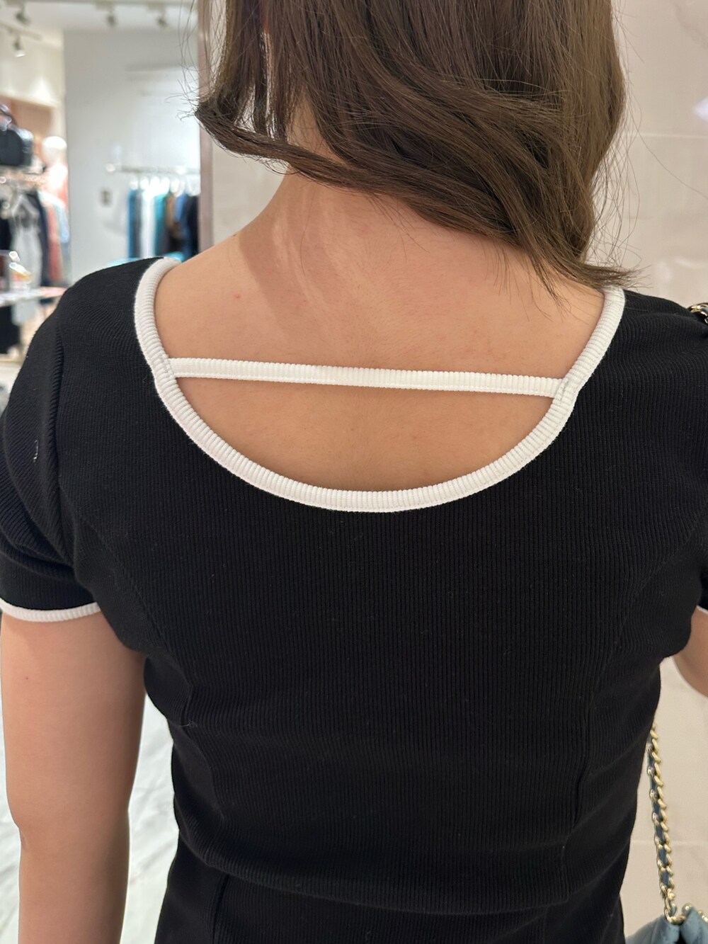 ブルー系のショルダーバッグ、ブラウン系のブーツ、ブラック系のワンピースを着用したレディースの春コーディネートの6枚目の写真