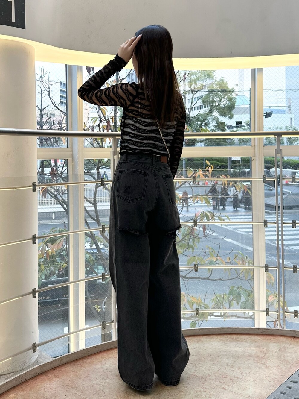 ブラック系のショルダーバッグ、ブラック系のデニムパンツ、ブラック系のTシャツ/カットソーを着用したレディースの冬コーディネートの2枚目の写真