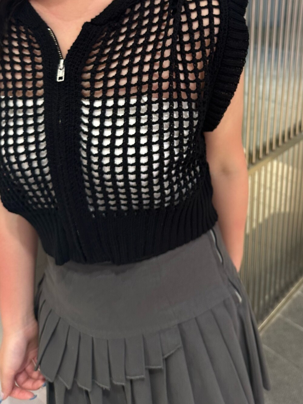 ブラック系のニット/セーター、グレー系のスカート、ブラック系のサンダルを着用したレディースの夏コーディネートの5枚目の写真