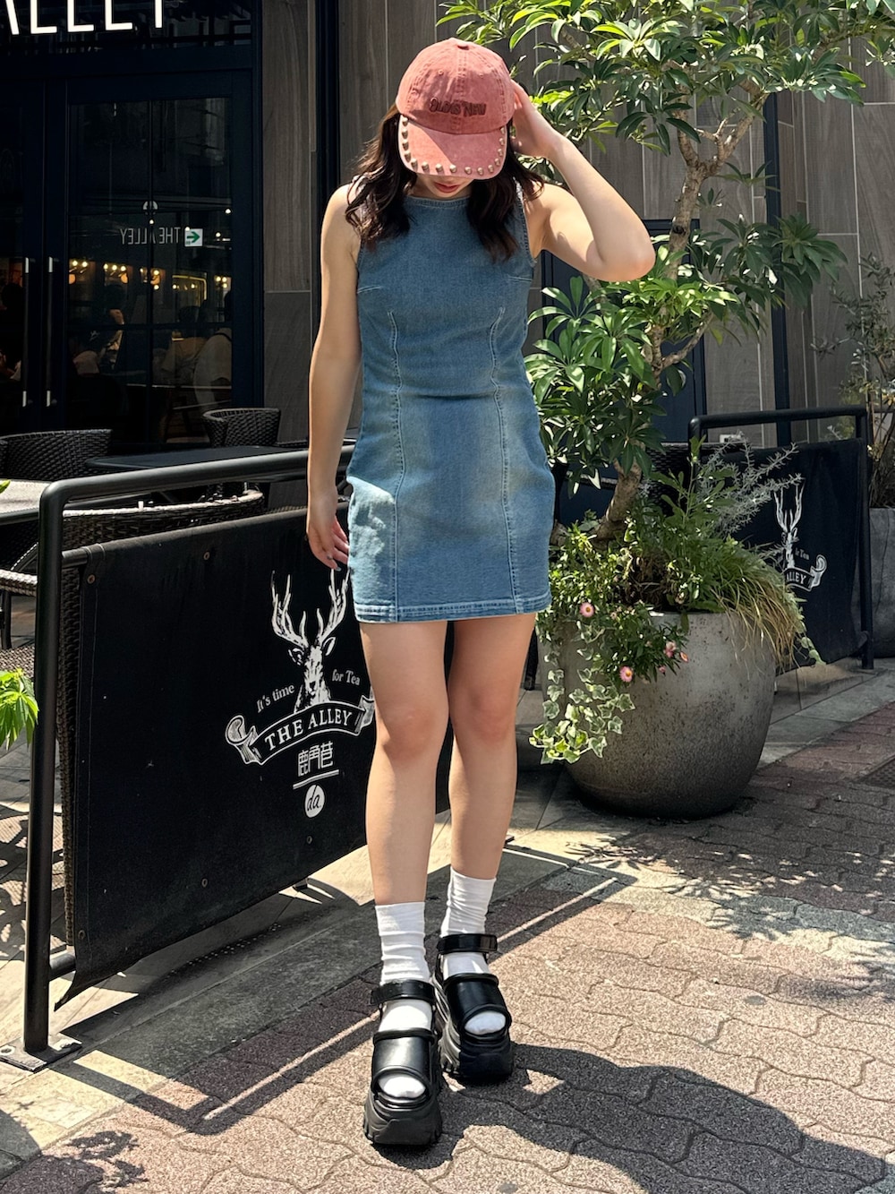 ブルー系のワンピース、ブラック系のサンダル、レッド系のキャップを着用したレディースの夏コーディネートの2枚目の写真