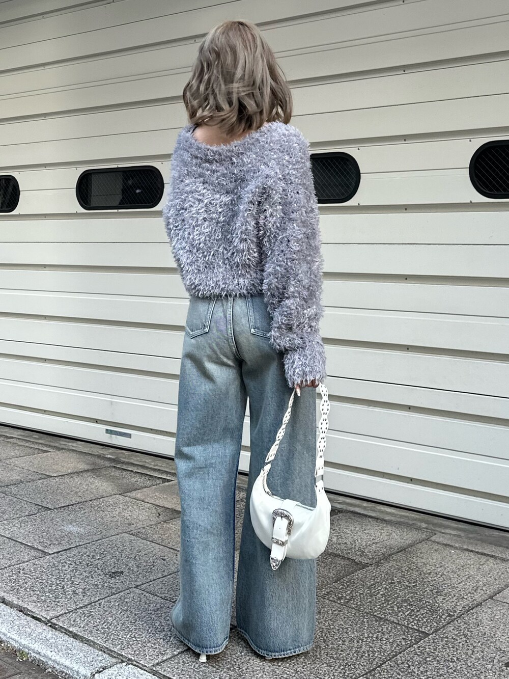 グレー系のカーディガン/ボレロ、ブルー系のデニムパンツを着用したレディースの冬コーディネートの3枚目の写真