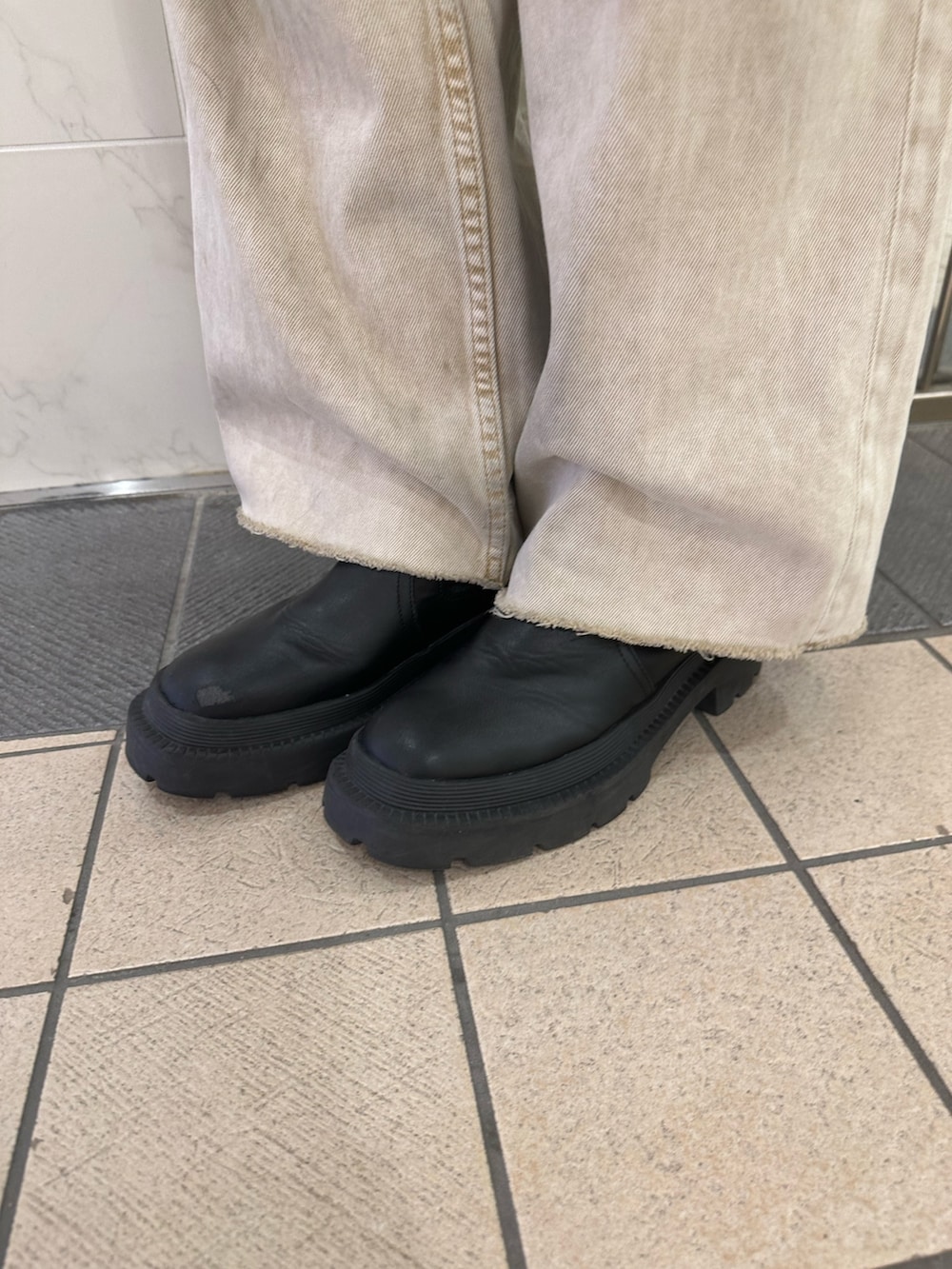 ベージュ系のニット/セーター、ベージュ系のデニムパンツ、ブラック系のブーツを着用したレディースの春コーディネートの8枚目の写真