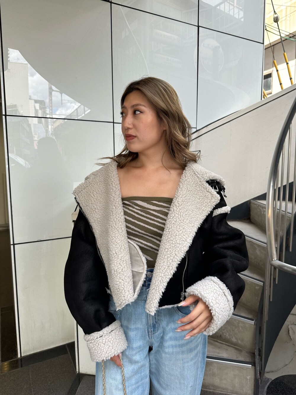 ブルー系のデニムパンツ、グリーン系のチューブトップ、ブラック系のショルダーバッグを着用したレディースの夏コーディネートの5枚目の写真