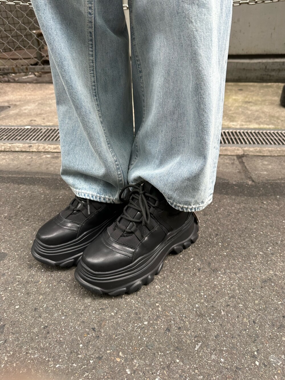 ブラック系のTシャツ/カットソー、ブラック系のスニーカー、ブルー系のデニムパンツを着用したレディースの春コーディネートの9枚目の写真