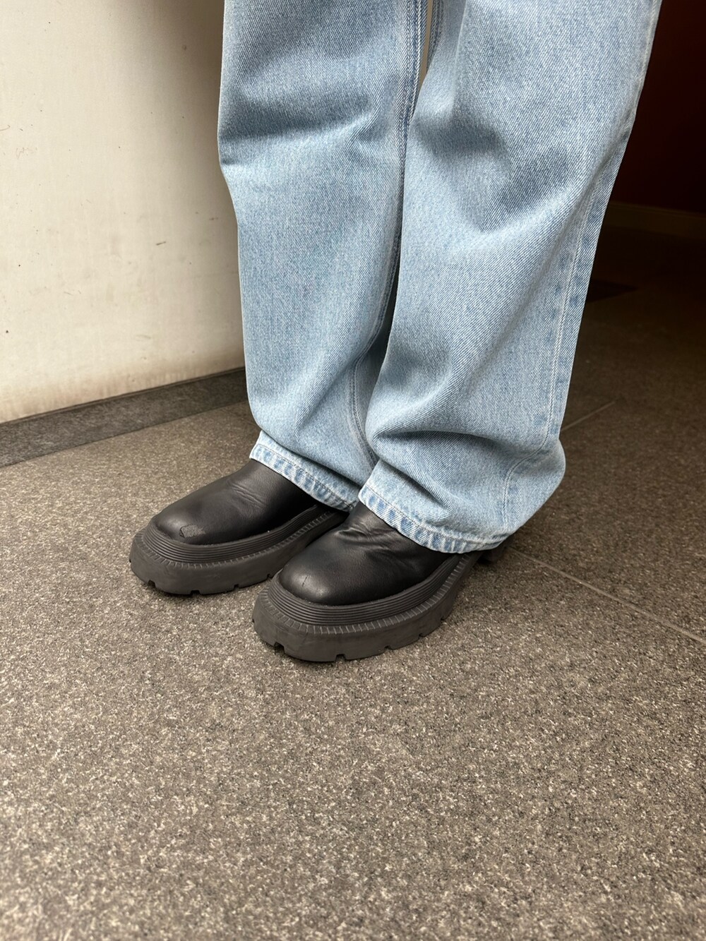 ブラック系のニット/セーター、ブルー系のデニムパンツ、グリーン系のショルダーバッグを着用したレディースの春コーディネートの7枚目の写真