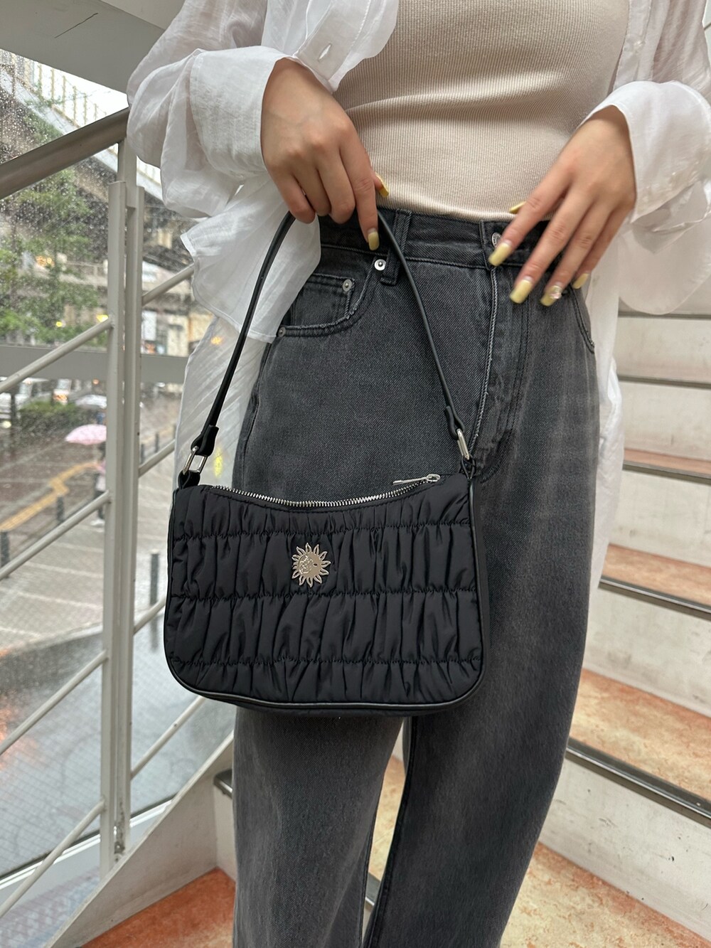 ブラック系のサンダル、ブラック系のハンドバッグ、ブラック系のデニムパンツを着用したレディースの夏コーディネートの9枚目の写真