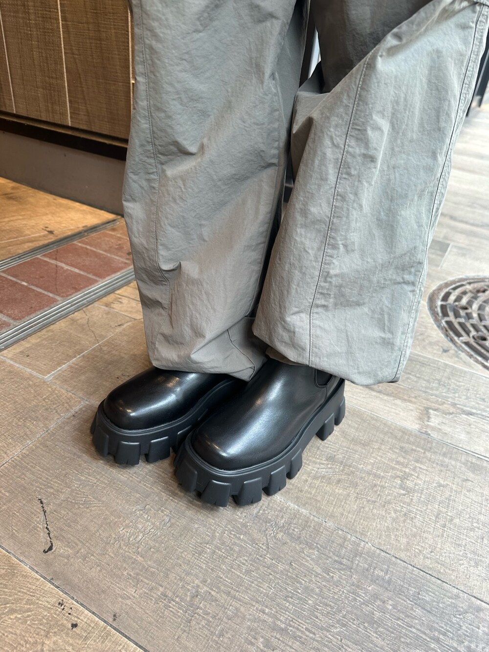 グレー系のカーゴパンツ、ブラック系のTシャツ/カットソー、ブラック系のブーツを着用したレディースの秋コーディネートの8枚目の写真