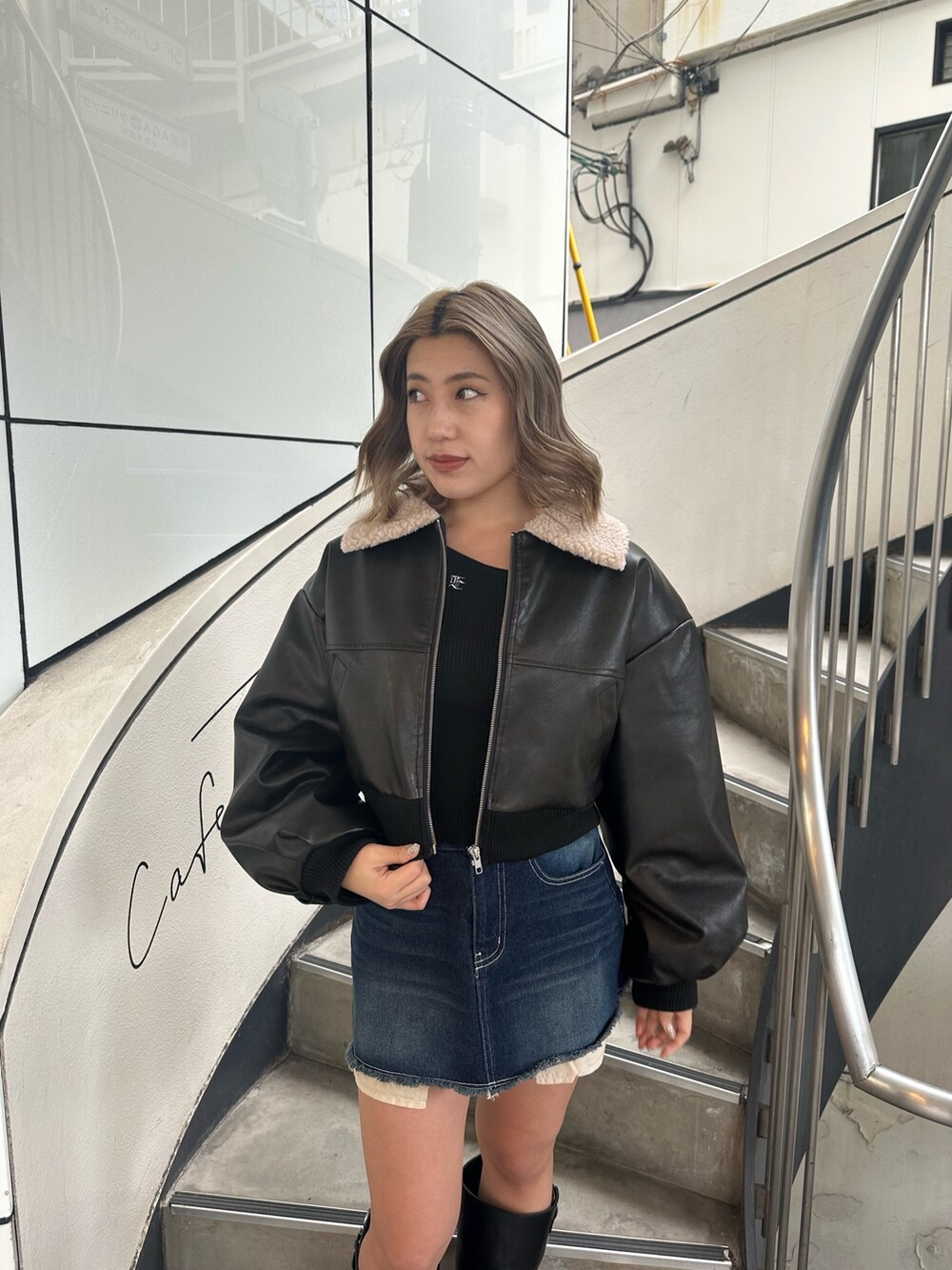 ブルー系のデニムスカート、ブラック系のブーツ、ブラック系のブルゾンを着用したレディースの冬コーディネートの4枚目の写真