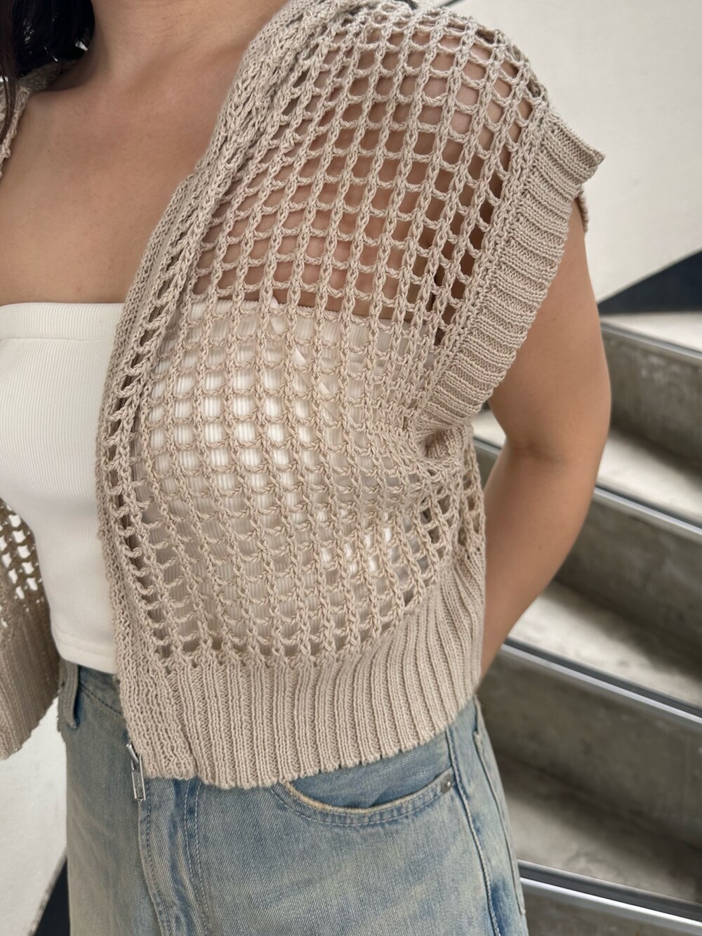 ホワイト系のニット/セーター、ブルー系のデニムパンツ、ブラック系のサンダルを着用したレディースの夏コーディネートの7枚目の写真