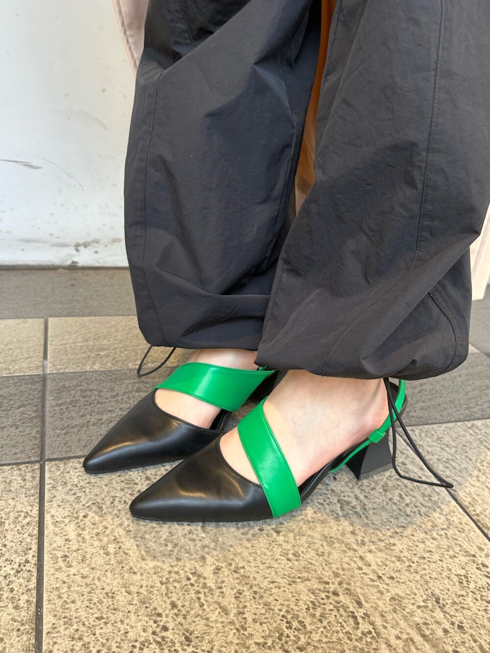 ベージュ系のトレンチコート、ブラック系のカーゴパンツ、ホワイト系のTシャツ/カットソーを着用したレディースの春コーディネートの7枚目の写真