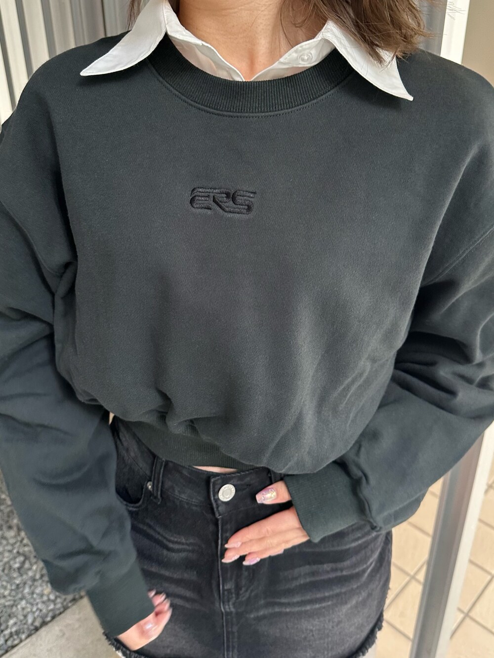 ブラック系のデニムスカート、ブラウン系のブーツ、ブラック系のスウェットを着用したレディースの冬コーディネートの5枚目の写真